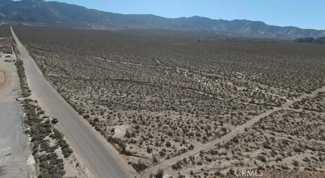 a view of a dry yard with mountains in the background