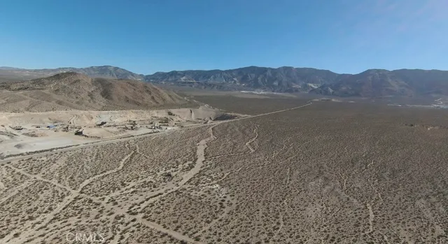 a view of a dry field with mountains in the background