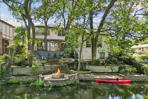 a view of house with a yard and a large tree