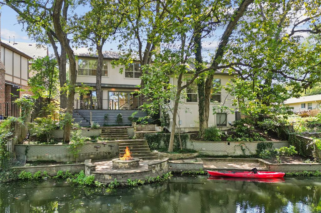 a view of house with a yard and a large tree