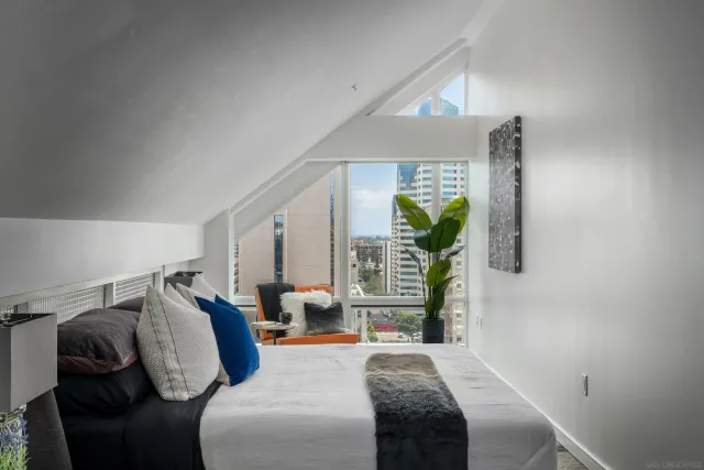 a bedroom with a bed and a lamp on the dresser