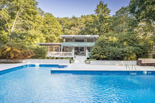 a view of a house with pool and a yard