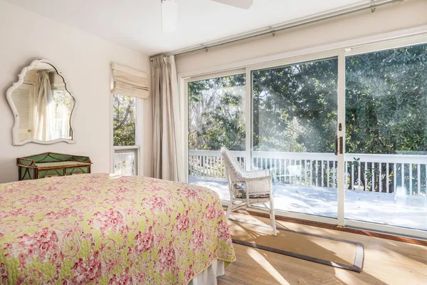 a bedroom with a bed and large windows