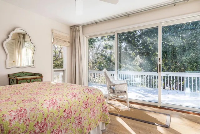 a bedroom with a bed and large windows