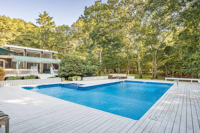 a view of a house with pool and sitting area