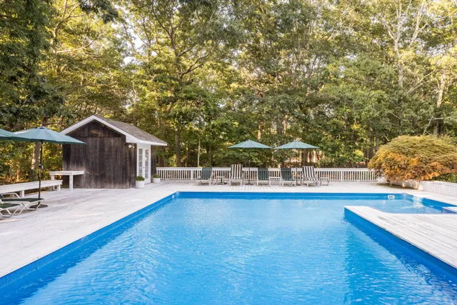 a view of a house with pool and sitting area