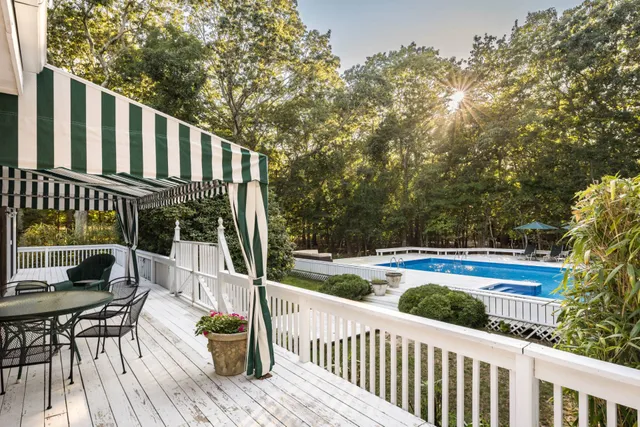 a balcony with wooden floor and outdoor seating
