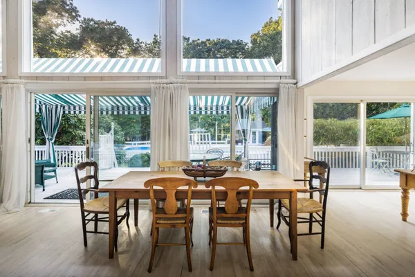 a view of a dining room with furniture wooden floor and a floor to ceiling window