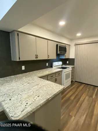 a kitchen with stainless steel appliances granite countertop a stove a sink and a microwave