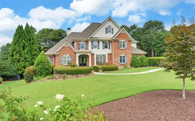 a front view of a house with a garden and plants