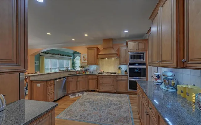 a bathroom with a granite countertop sink a large mirror and a shower