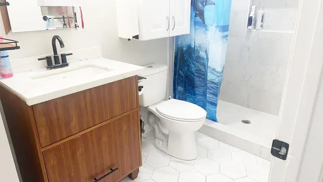 a bathroom with a sink a toilet and shower