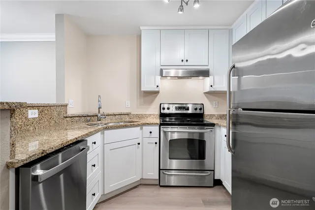 a kitchen with stainless steel appliances granite countertop a refrigerator sink and cabinets