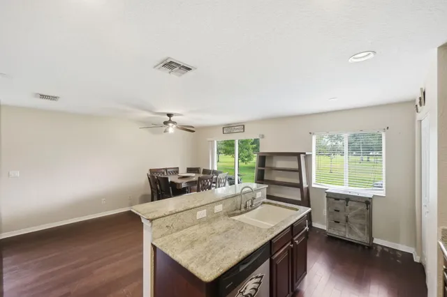 a view of a kitchen with granite countertop a stove and a wooden floor