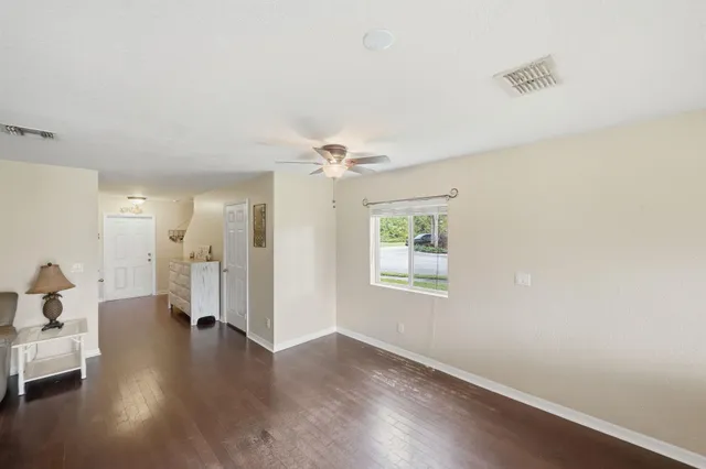 a view of a livingroom with wooden floor and a ceiling fan