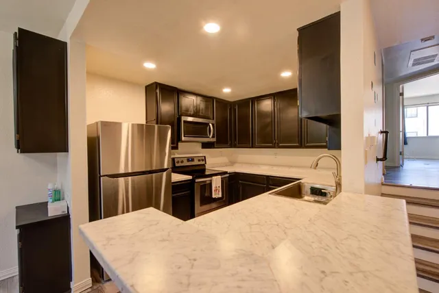 a kitchen with kitchen island a counter top space appliances and cabinets