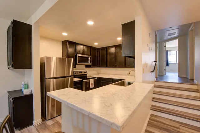 a kitchen with stainless steel appliances refrigerator stove microwave and stove