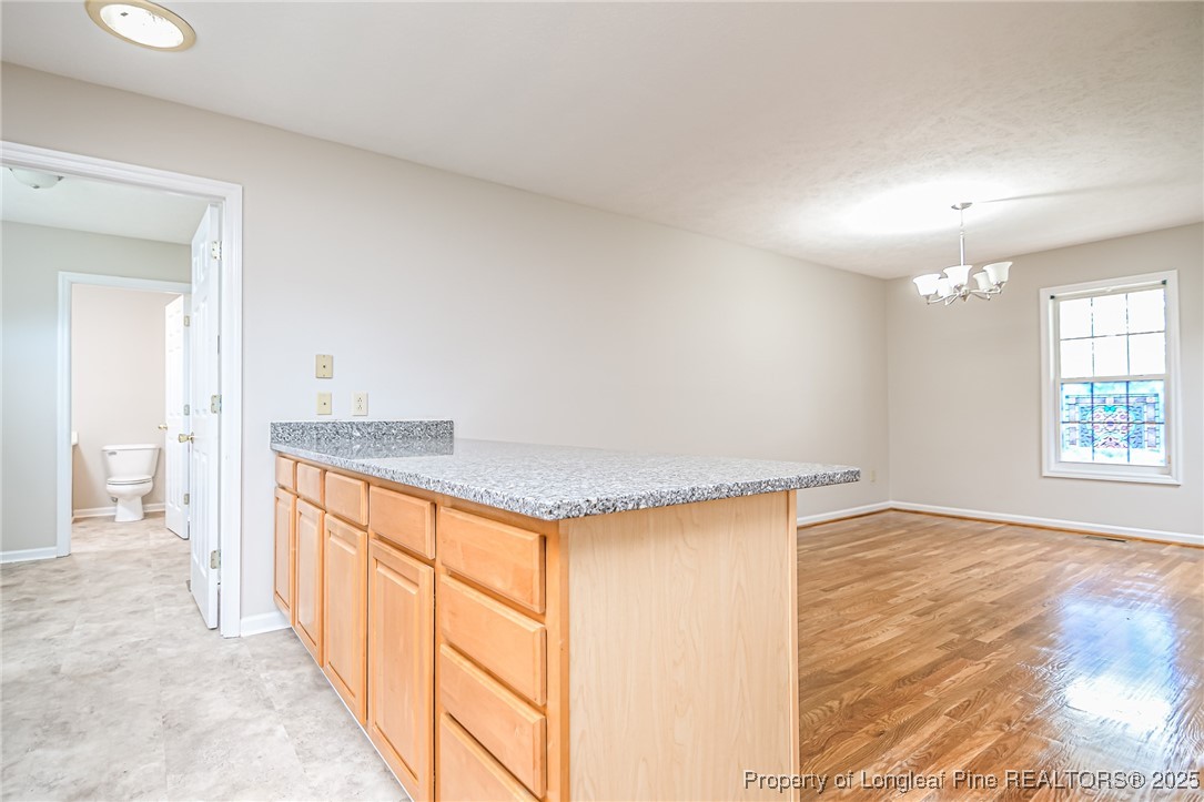 4735 Camden Road Fayetteville, NC 28306 - Photo 15 of 34 a view of a kitchen with kitchen island a sink wooden floor and a large window