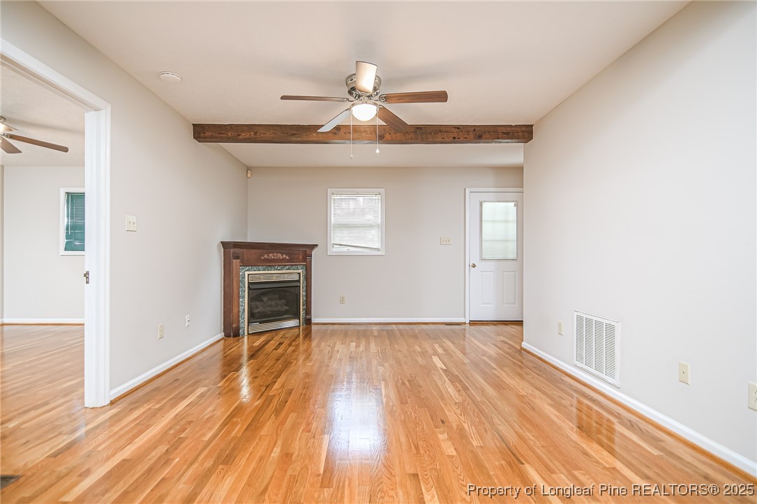 4735 Camden Road Fayetteville, NC 28306 - Photo 5 of 34 a view of an empty room with wooden floor and a fireplace