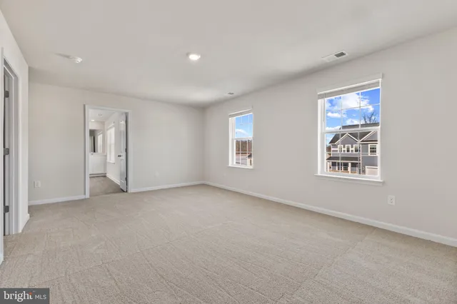 an empty room with windows and closet