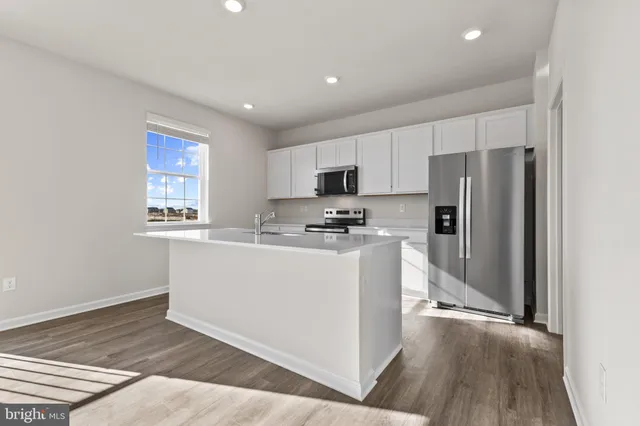 a kitchen with cabinets and wooden floor