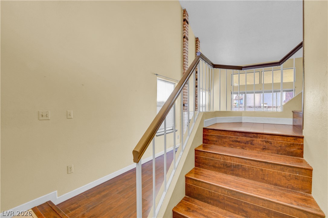 6440 Hartwood Road Las Vegas, NV 89108 - Photo 25 of 59 Rich hardwood stairs ascend to an inviting upper landing, bathed in light from a large window.