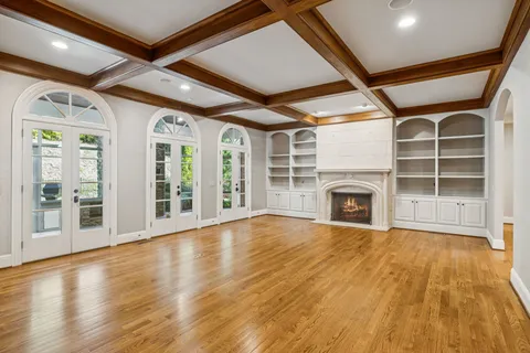 a view of an empty room with a fireplace and a window