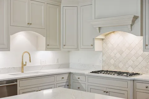 a kitchen with white cabinets and appliances