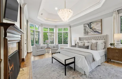 a bedroom with a large bed and a chandelier