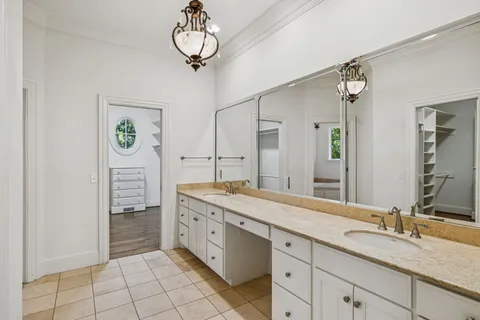 a spacious bathroom with a granite countertop sink a mirror and a shower