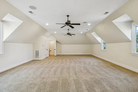an empty room with ceiling fan and window