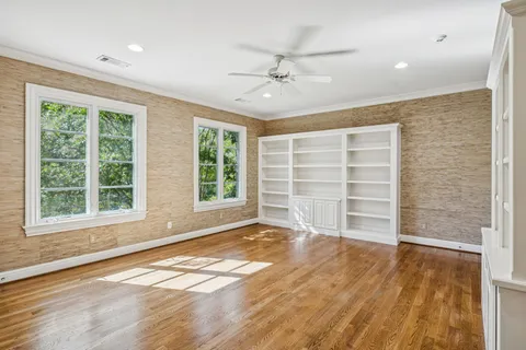 a view of an empty room with a window and wooden floor