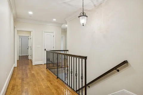 a view of a hallway with wooden floor and staircase