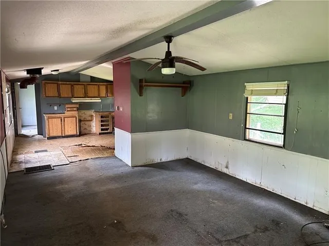 a view of a livingroom with a ceiling fan and window