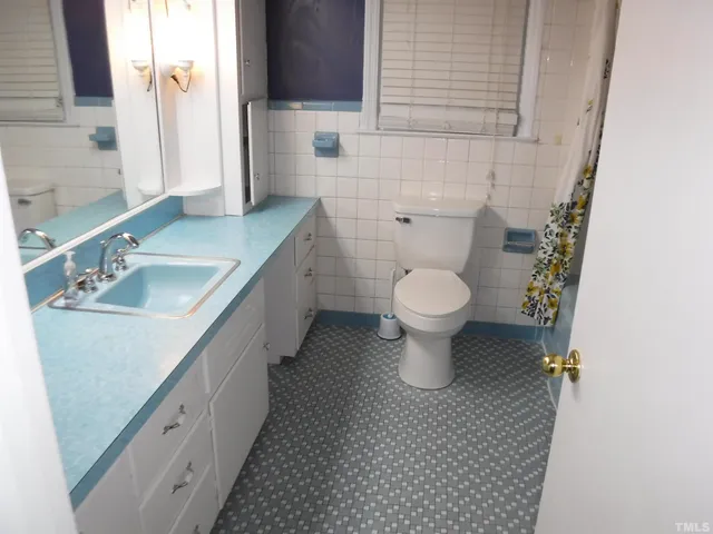 a bathroom with a granite countertop toilet a sink and a mirror