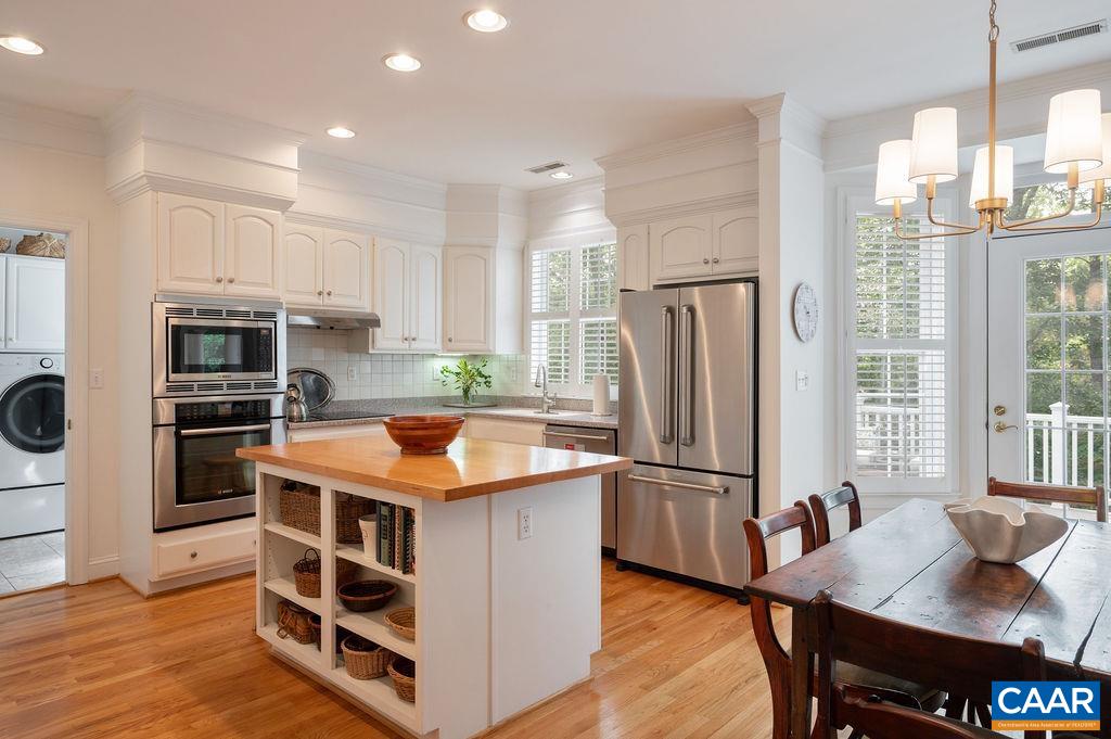 3515 Devon Pines Keswick, VA 22947 - Photo 29 of 68 a kitchen with stainless steel appliances granite countertop a refrigerator a stove a sink a dining table and chairs