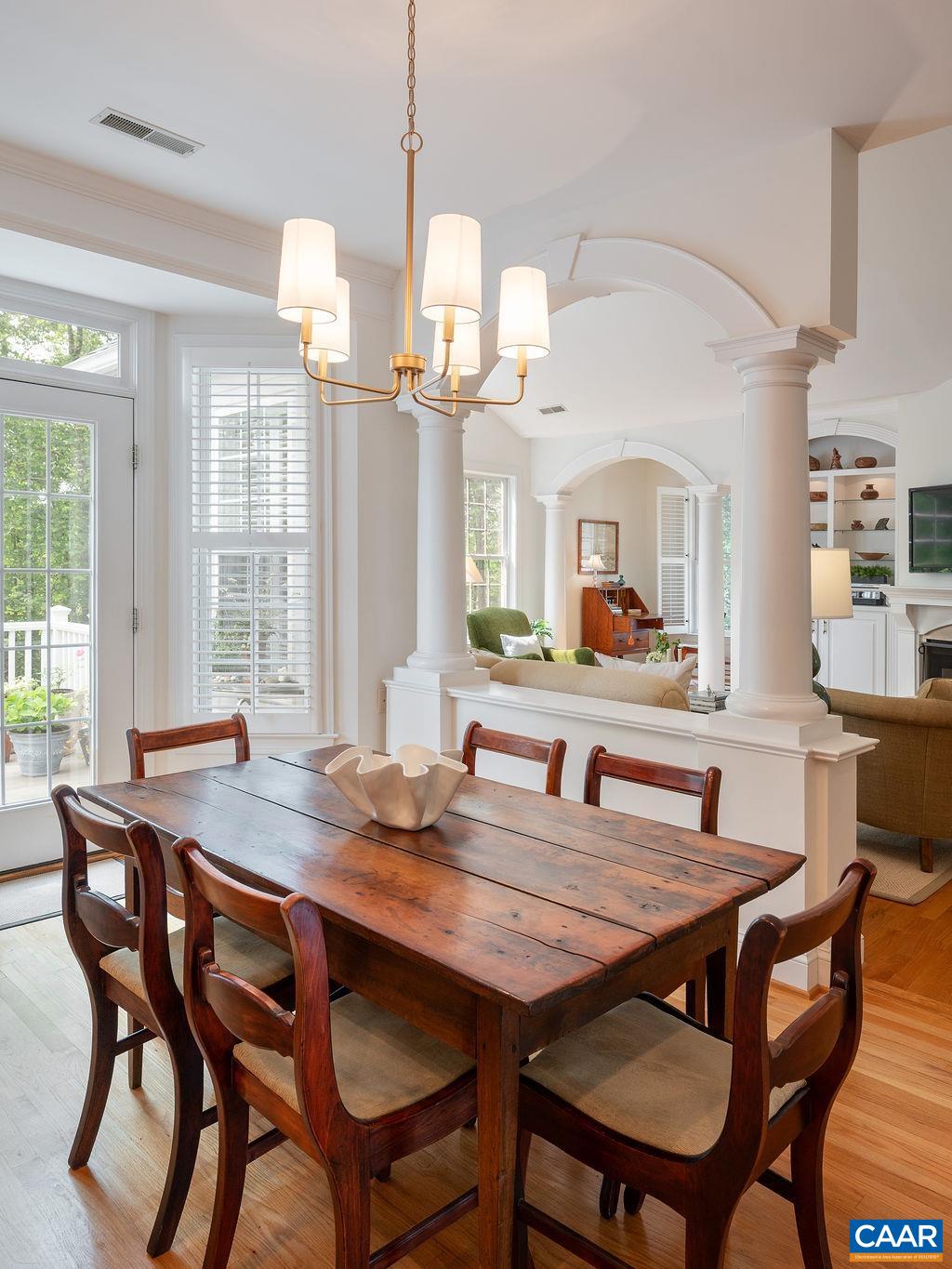 3515 Devon Pines Keswick, VA 22947 - Photo 30 of 68 a dining room with wooden floor a chandelier a wooden table and chairs