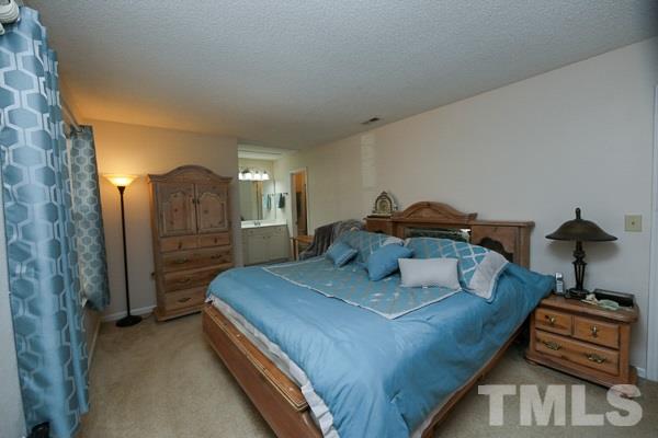 7717 Falcon Rest Circle, Unit 7717 Raleigh, NC 27615 - Photo 8 of 14 a bedroom with a bed and a chandelier