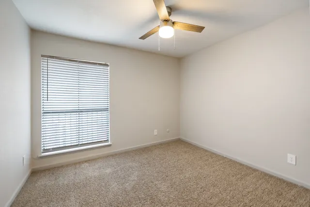 an empty room with a window and fireplace