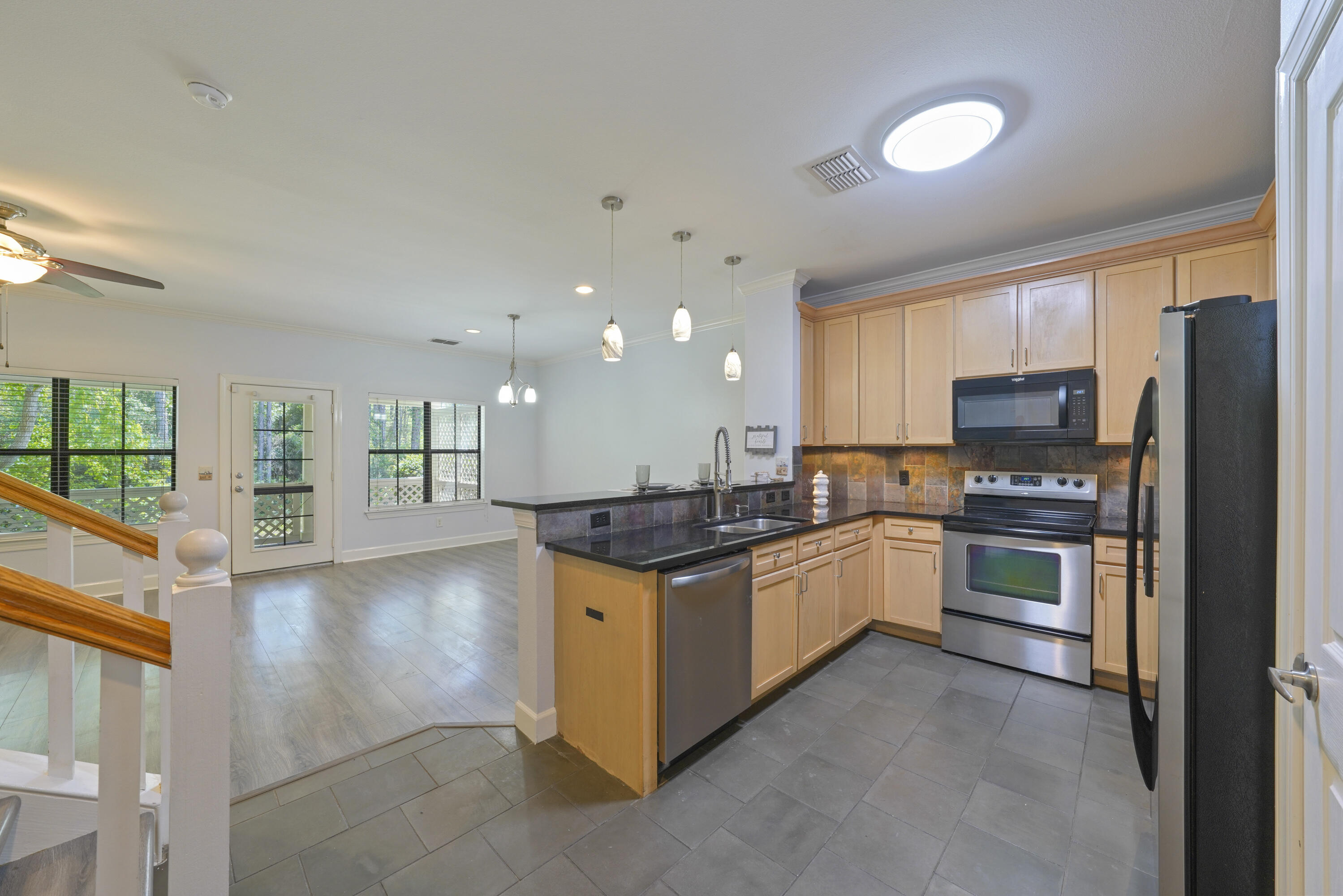 a kitchen with stainless steel appliances granite countertop a stove top oven a sink and a refrigerator
