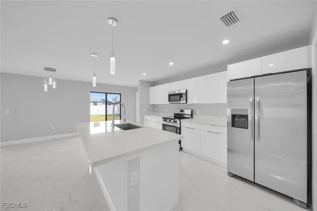 a kitchen with stainless steel appliances a refrigerator sink and stove