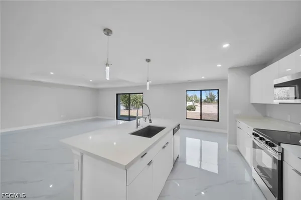 a kitchen with stainless steel appliances granite countertop a sink a stove and a refrigerator