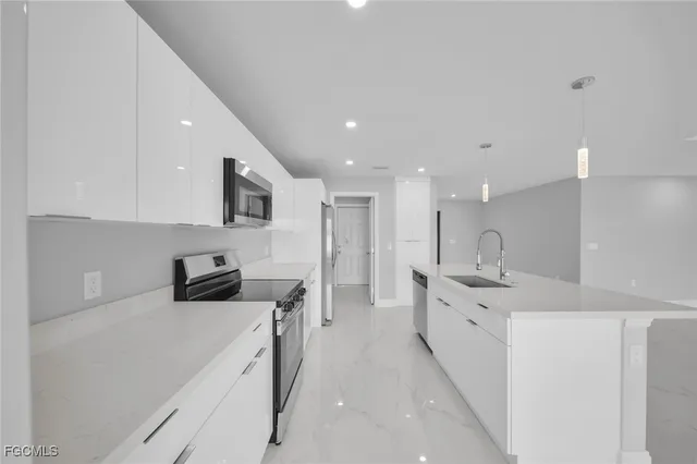 a kitchen with stainless steel appliances sink stove refrigerator and cabinets