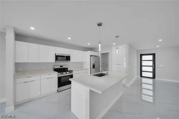 a kitchen with stainless steel appliances kitchen island sink stove and cabinets