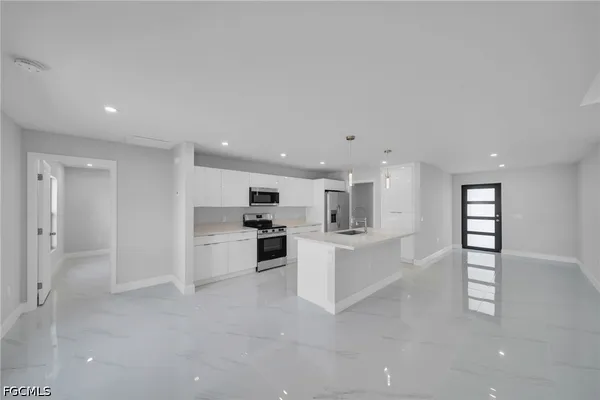 a large white kitchen with white cabinets and a stove top oven