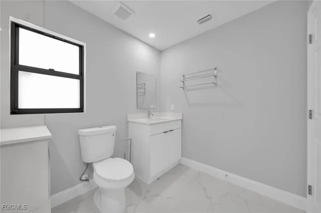 a white toilet sitting next to a bathroom sink