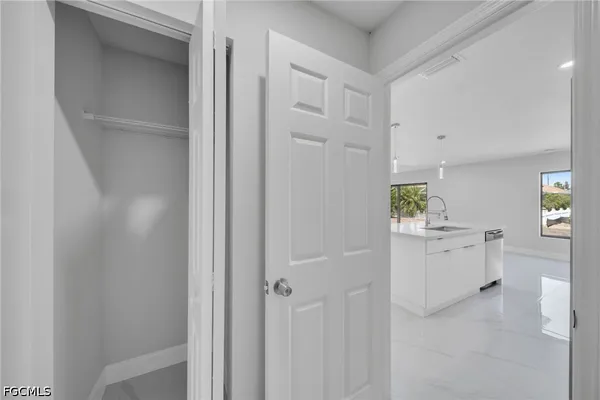 a kitchen with white cabinets and sink