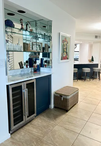 a living room with stainless steel appliances kitchen island granite countertop a sink and cabinets