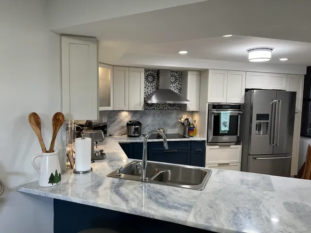 a kitchen with granite countertop a sink stainless steel appliances and cabinets
