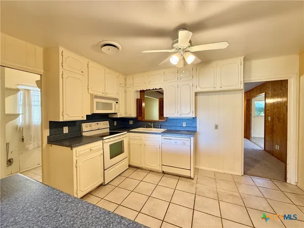 a kitchen with a stove a refrigerator and cabinets